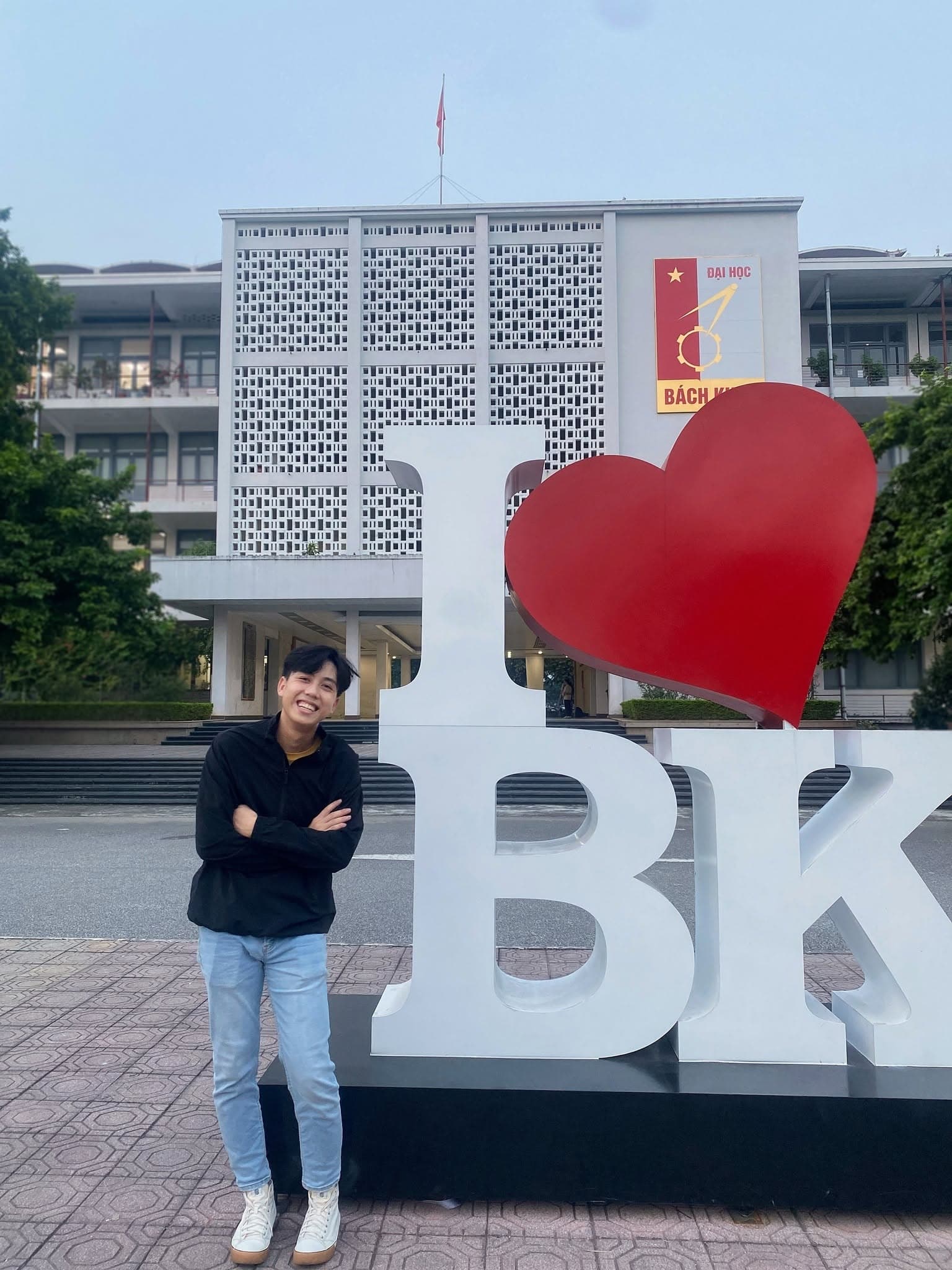 Michael standing beside the I love BK sign at Hanoi University of Science and Technology